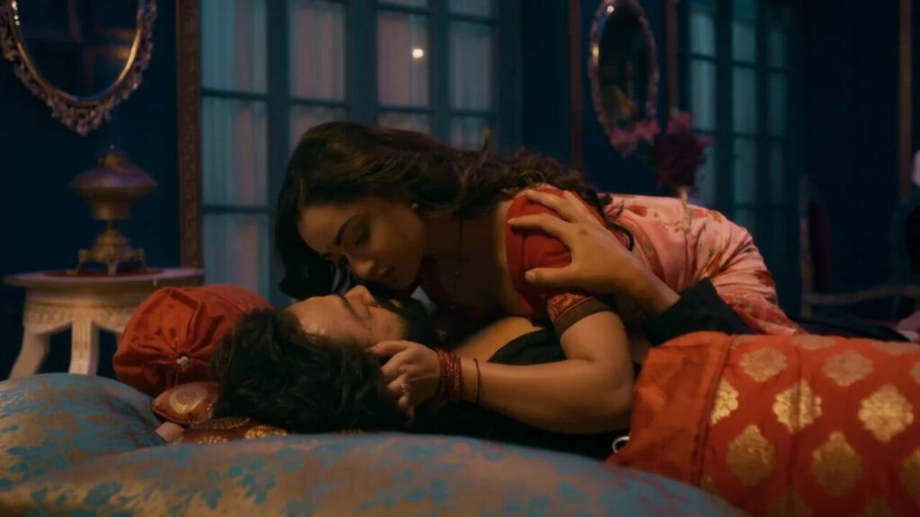 A women is laying on a men in Aashram Web Series Scene